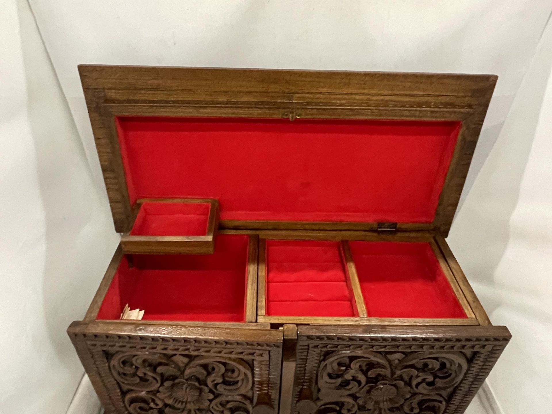 A HEAVILY CARVED JEWELLERY BOX WITH TWO DOORS REVEALING FOUR LINED DRAWERS AND A LIFT UP LID WITH - Image 2 of 4