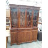 A MODERN YEW WOOD BREAKFRONT THREE DOOR GLAZED BOOKCASE ON BASE, 61" WIDE