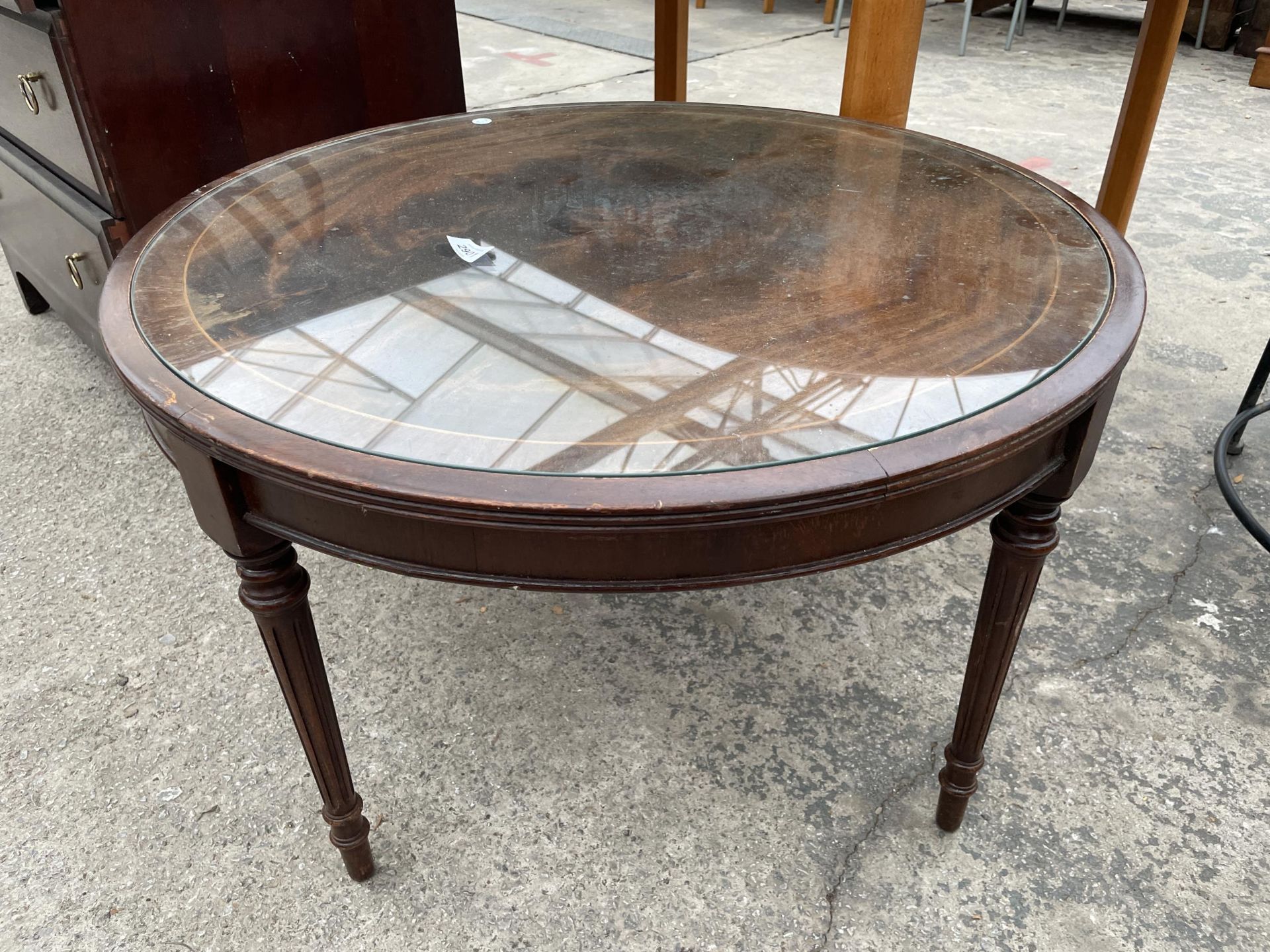 A MODERN 29" DIAMETER MAHOGANY COFFEE TABLE ON TURNED AND FLUTED LEGS