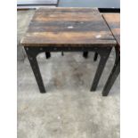 AN INDUSTRIAL STYLE TABLE ON CAST METAL AND STUDDED LEGS AND FRAME, WITH WOOD BLOCK TOP, 28" SQUARE