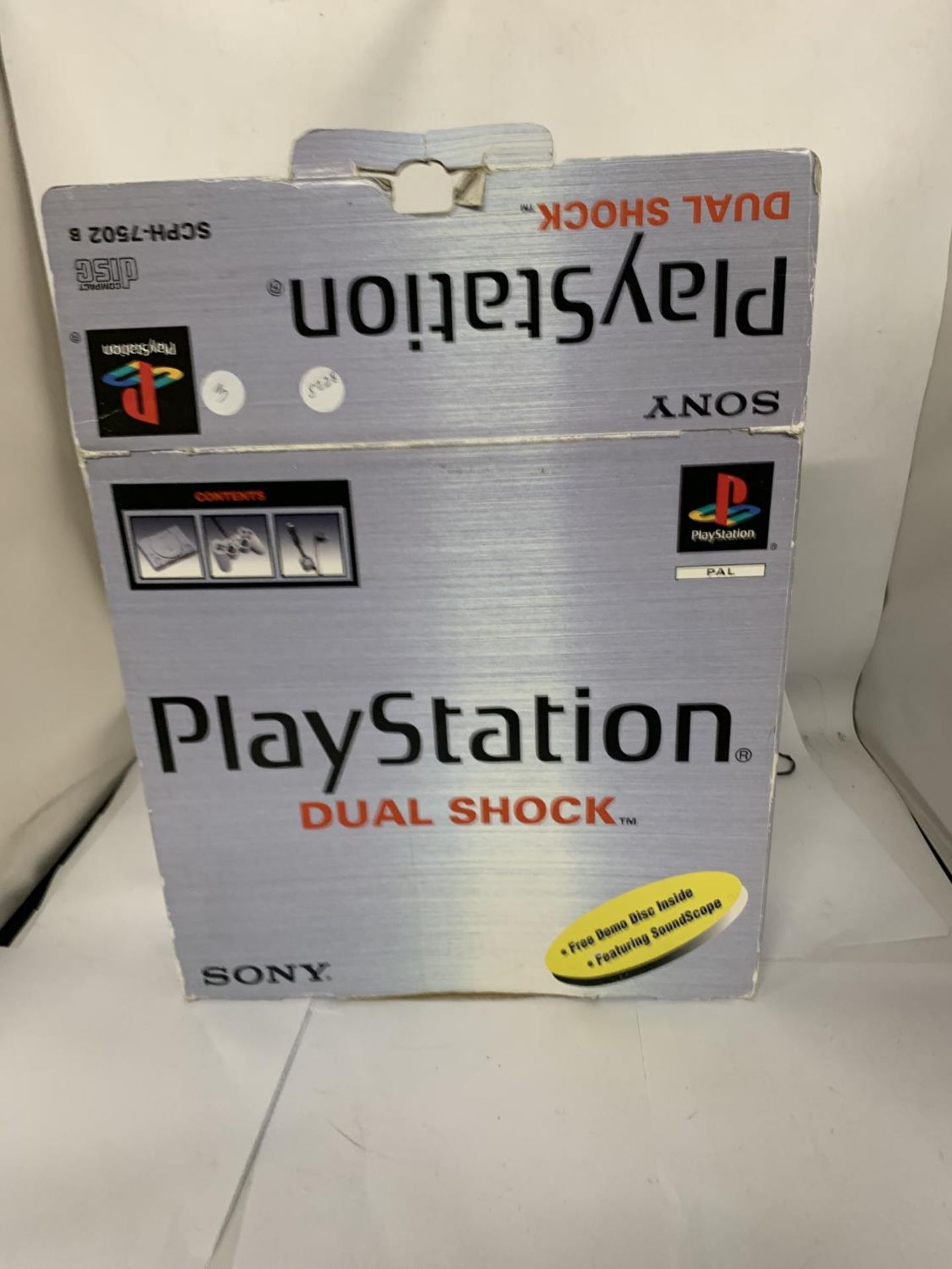 A BOXED PLAYSTATION ONE TOGETHER WITH DUAL SHOCK CONTROLLER