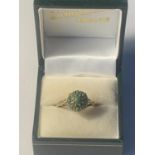 A 9 CARAT GOLD RING WITH GREEN STONES IN A FLOWER DESIGN SIZE R GROSS WEIGHT 3.34 GRAMS IN A