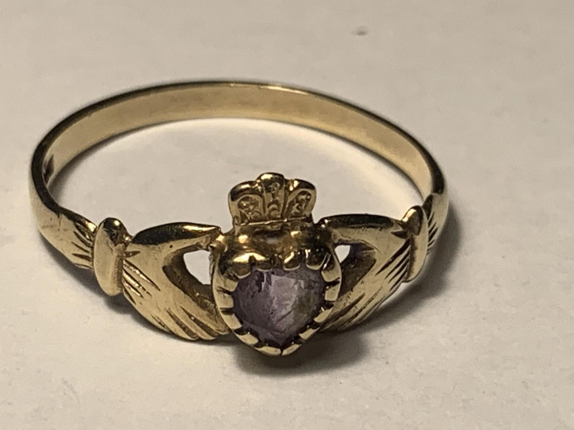 A 9 CARAT GOLD CLADDAGH RING WITH AN AMETHYST SIZE N/O