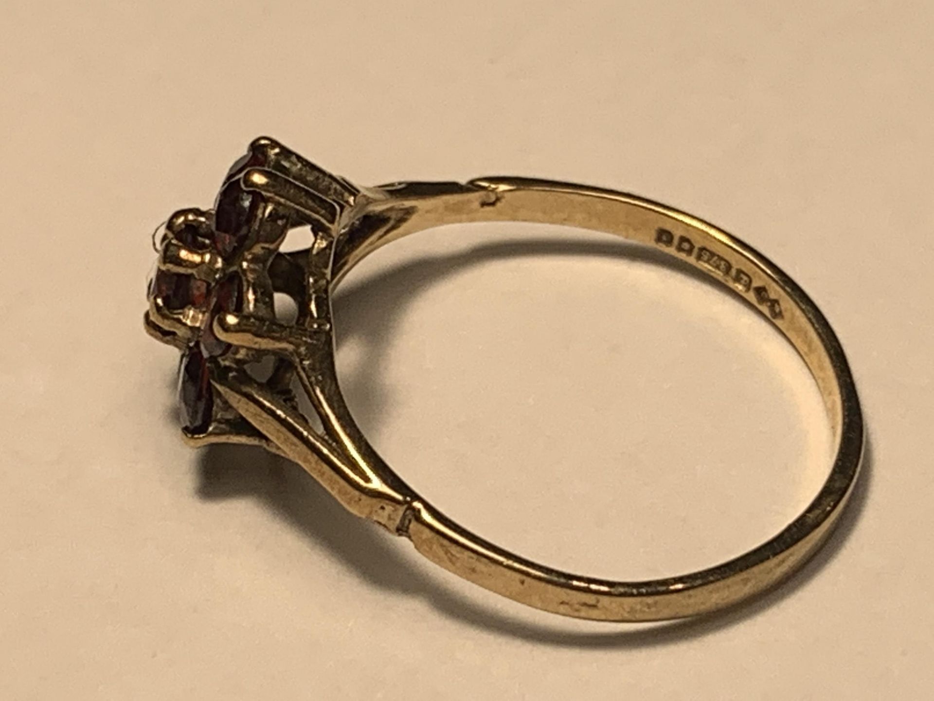 A 9 CARAT GOLD RING WITH SEVEN GARNETS IN A FLOWER DESIGN SIZE M - Image 2 of 3