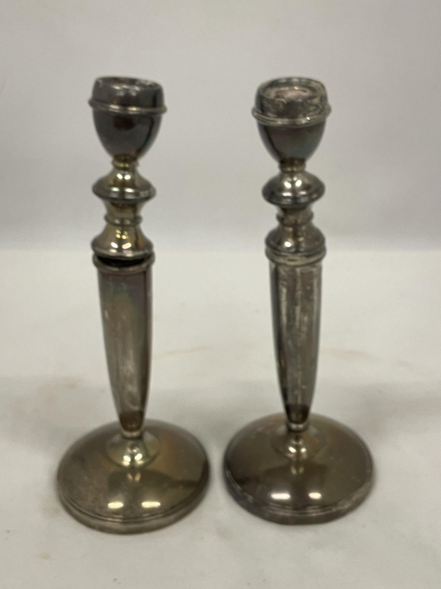 A PAIR OF HALLMARKED BIRMINGHAM SILVER CANDLESTICKS (ONE A/F) WITH WEIGHTED BASES