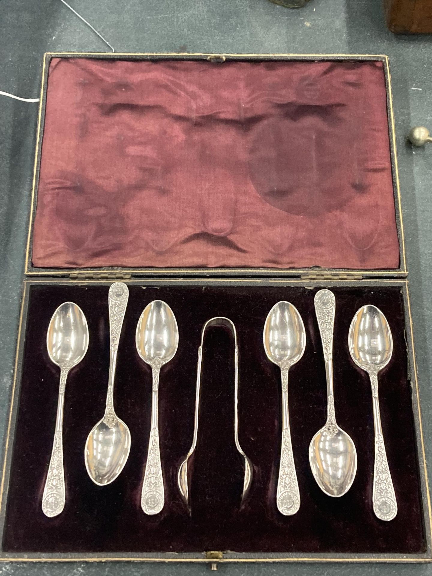 A VINTAGE CASED SILVER PLATED TEASPOONS AND SUGAR TONGS SET