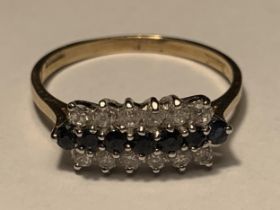 A 9 CARAT GOLD RING WITH SEVEN IN LINE SAPPHIRES WITH A LINE OF SIX CUBIC ZIRCONIAS EACH SIDE SIZE