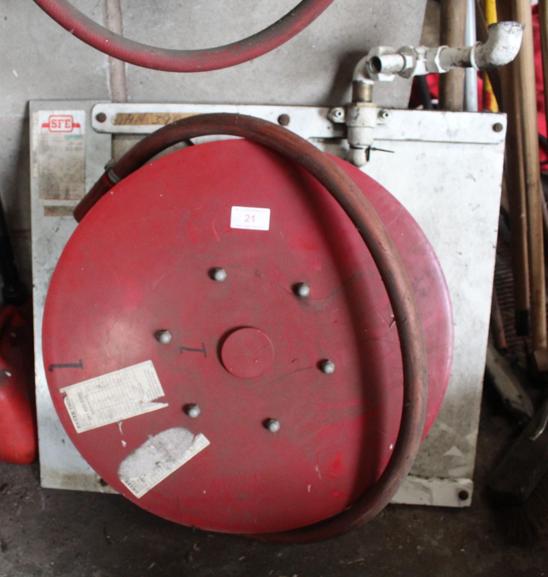 A FIRE HOSE REEL ON A WOODEN BOARD WITH A FIRE HOSE