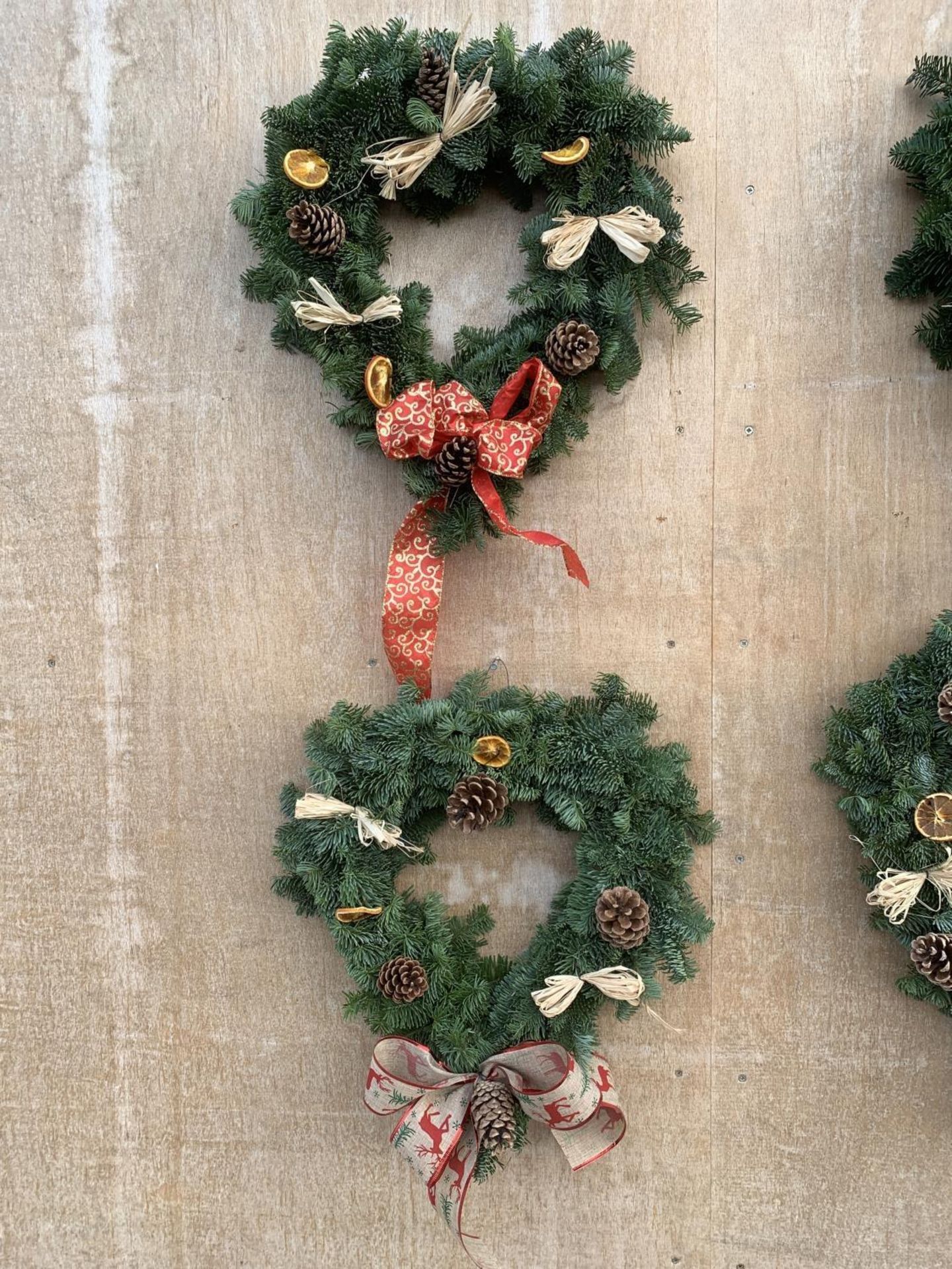 TWO HEART SHAPED WREATHS WITH ORANGE, RAFIA, CONE AND RIBBON + VAT TO BE SOLD FOR TWO