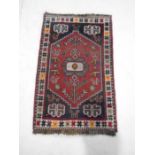 A small red ground rug - overall size 112cm x 72cm