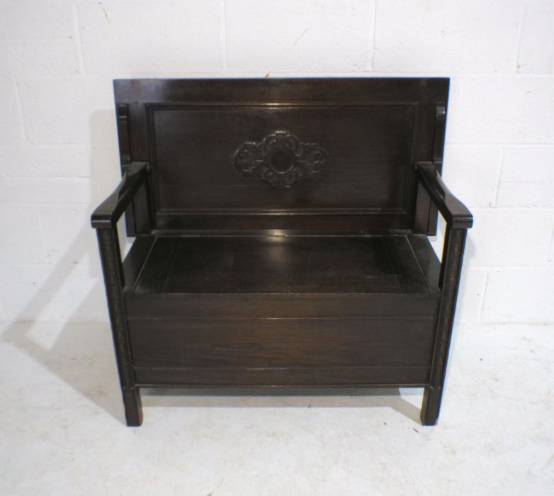 An oak monk's bench with lift up seat and carved detailing, marked 'Raleigh Furniture', length