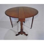 A Victorian oval drop leaf table on turned legs.