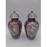 A pair of Japanese Imari vases and covers, 1 lid repaired, overall height 26cm