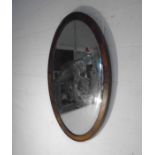 An Edwardian oval wall mirror.