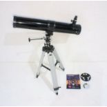 A Celestron Firstscope 114EQ telescope on adjustable tripod stand with instruction manual.