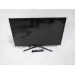 A Samsung flat screen TV with remote control - Model no UE39F5500AK