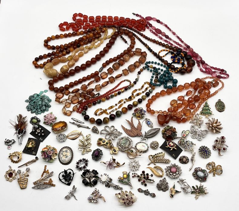 A collection of vintage costume jewellery including a number of beads, amber coloured necklaces