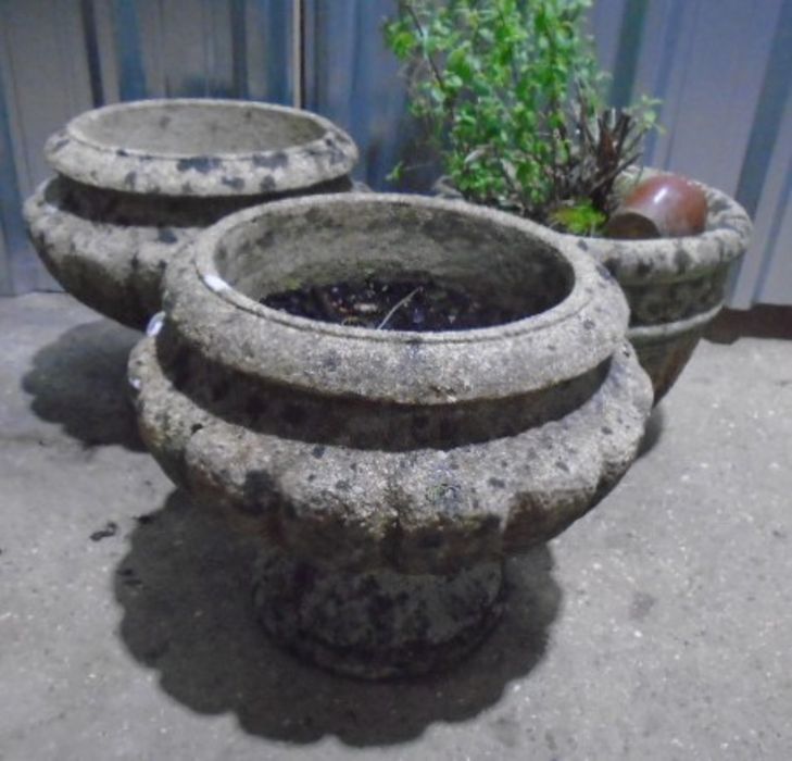 Two matching reconstituted stone garden planters, plus one other. Approximate height 35cm.