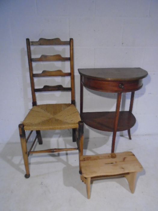 A vintage demi-lune table plus a ladder-back chair and a stool.,