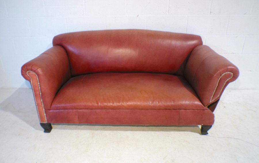 A modern red leather drop-arm sofa with brass stud detailing, length 173cm.