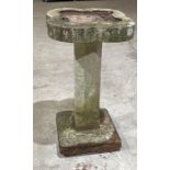 A one piece reconstituted stone quatrefoil bird bath.