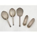 A hallmarked silver part dressing table set consisting of hand mirror and four brushes