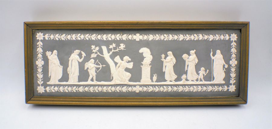 A Wedgwood jasperware plaque in black of a classical scene depicting Psyche bound to a tree whilst