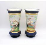 A pair of French porcelain vases with hand-painted decoration depicting storks in a natural setting,