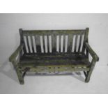 A weathered wooden garden bench - length 122cm