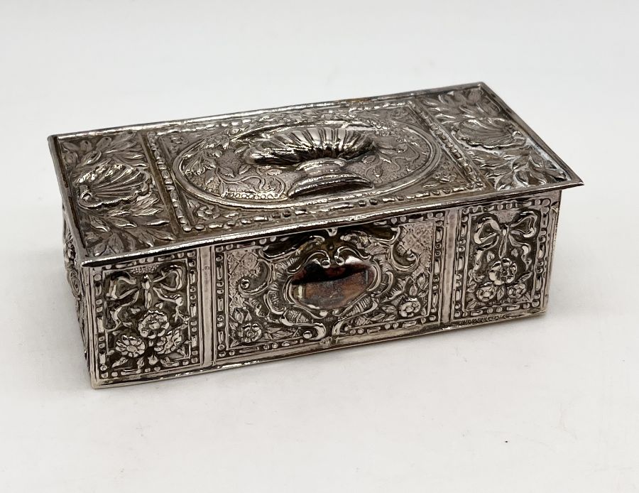 A small continental silver lidded box with embossed decoration and gilded interior