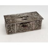 A small continental silver lidded box with embossed decoration and gilded interior