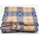 A woollen Welsh blanket with traditional reversible geometric pattern in pink and blue tones - 230cm