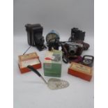 A small collection of cameras including a Voightlander Vito B, alarm clock etc.