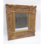 A decoratively gilt framed mirror. Label to the rear "Carvers & Gilders", England. Overall size 38cm