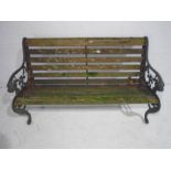 A wooden slatted garden bench with cast iron ends - length 126cm