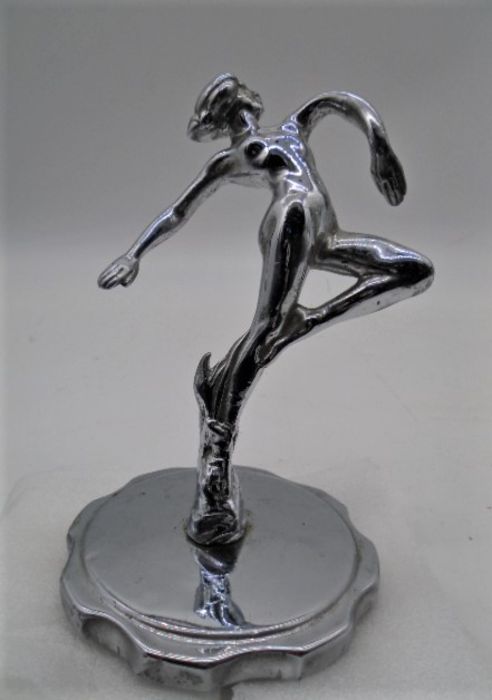 A chrome car mascot/hood ornament in the form of a female nude.