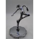 A chrome car mascot/hood ornament in the form of a female nude.