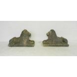 A pair of reconstituted stone recumbent lions, length 77cm, height 50cm.
