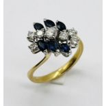 An 18ct gold ring set with 7 diamonds with sapphire surround
