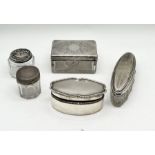 A collection of four silver topped dressing table pots along with a shaped oval silver pot- slightly