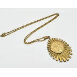 A 1911 full sovereign in loose mounted sunburst pendant with 9ct chain, total weight 19.5g