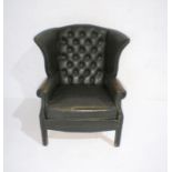 A green leather Chesterfield style wingback armchair with button-back detailing.