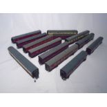 A collection of various OO gauge model railway maroon carriages including passenger coaches,