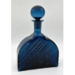 A blue glass decanter by Nanny Still for Riihimaki with waved pattern and rounded stopper