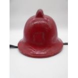 A vintage red firefighters helmet, marked inside medium, 1982. Leather adjustable chin strap and
