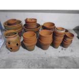 A collection of various sized terracotta garden pots etc