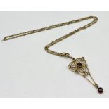 An Art Nouveau 9ct gold pendant set with garnets and seed pearls on a 9ct gold chain