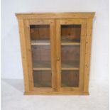 An antique pine freestanding bookshelf with glazed doors - length 92cm, height 111cm, depth 33cm.