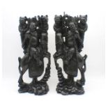 A pair of Oriental carvings of warriors on horseback, approximate height 53cm.