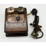 An early 20th century wooden cased telephone exchange with two bells and handset